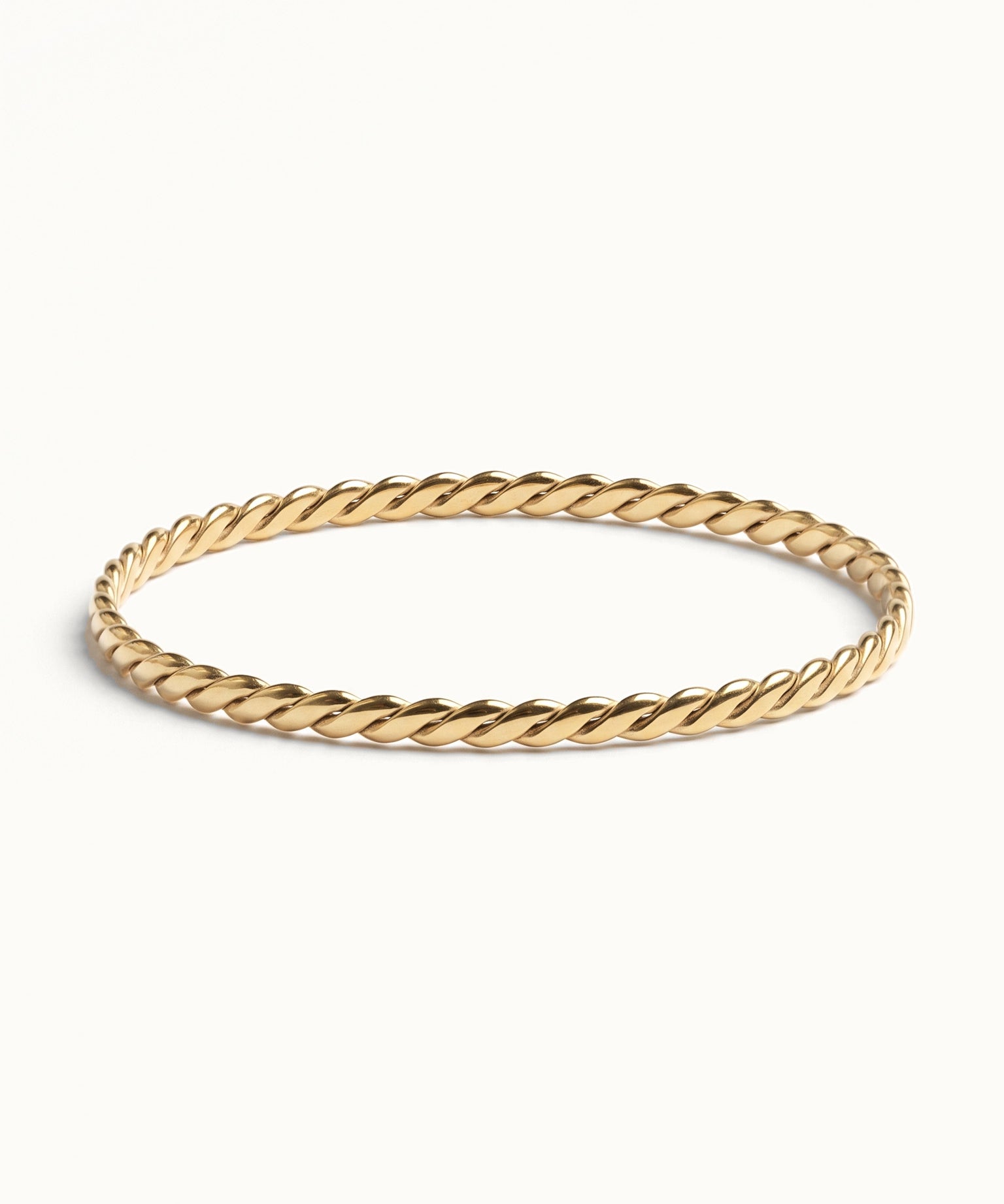 Kept Season Bangle – twisted rope-texture bangle, front view, gold, on ivory background