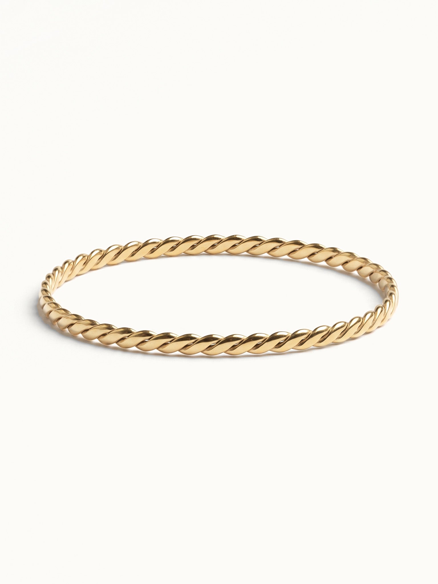 Kept Season Bangle – twisted rope-texture bangle, front view, gold, on ivory background