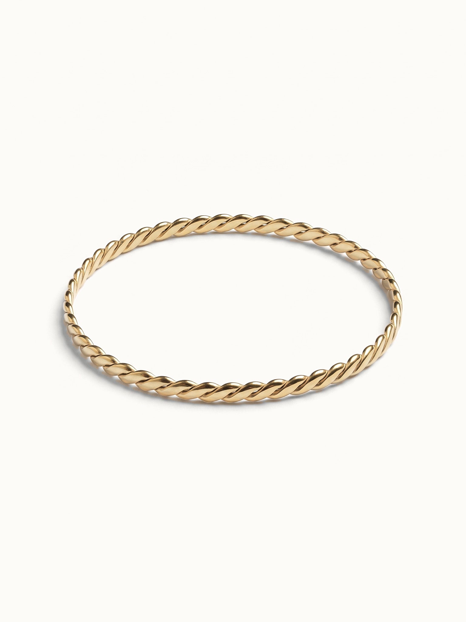 Kept Season Bangle – twisted rope-texture bangle, angled view, gold, on ivory background