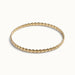 Kept Season Bangle – twisted rope-texture bangle, angled view, gold, on ivory background
