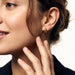 Morning Joy Studs – worn in the ear, close-up in profile with a hand at the neck, gold, ivory studio background