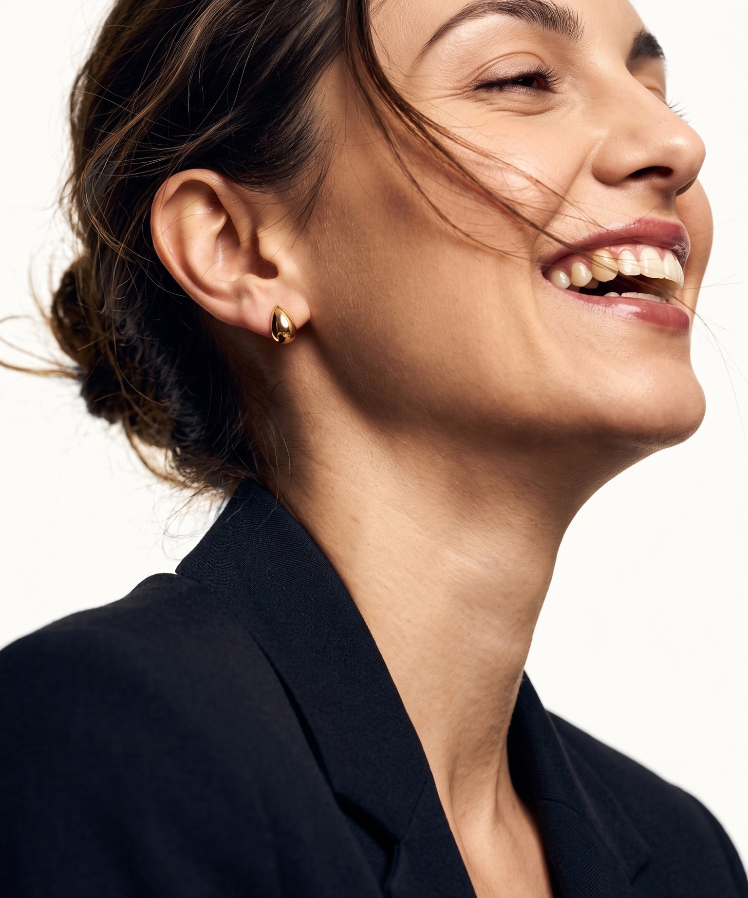 Morning Joy Studs – worn in the ear, laughing with hair in motion, gold teardrop stud, hair tied back