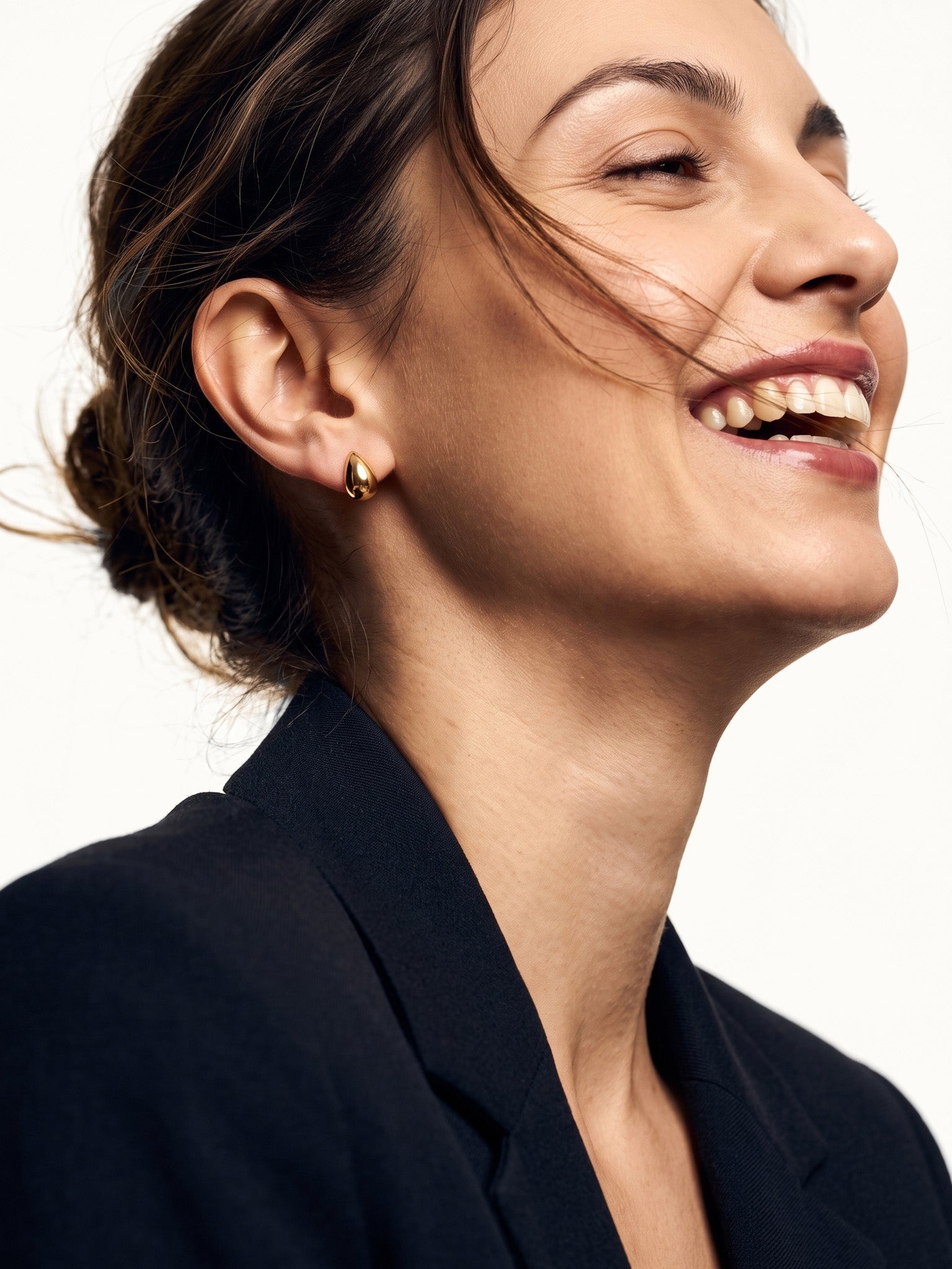 Morning Joy Studs – worn in the ear, laughing with hair in motion, gold teardrop stud, hair tied back