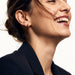 Morning Joy Studs – worn in the ear, laughing with hair in motion, gold teardrop stud, hair tied back
