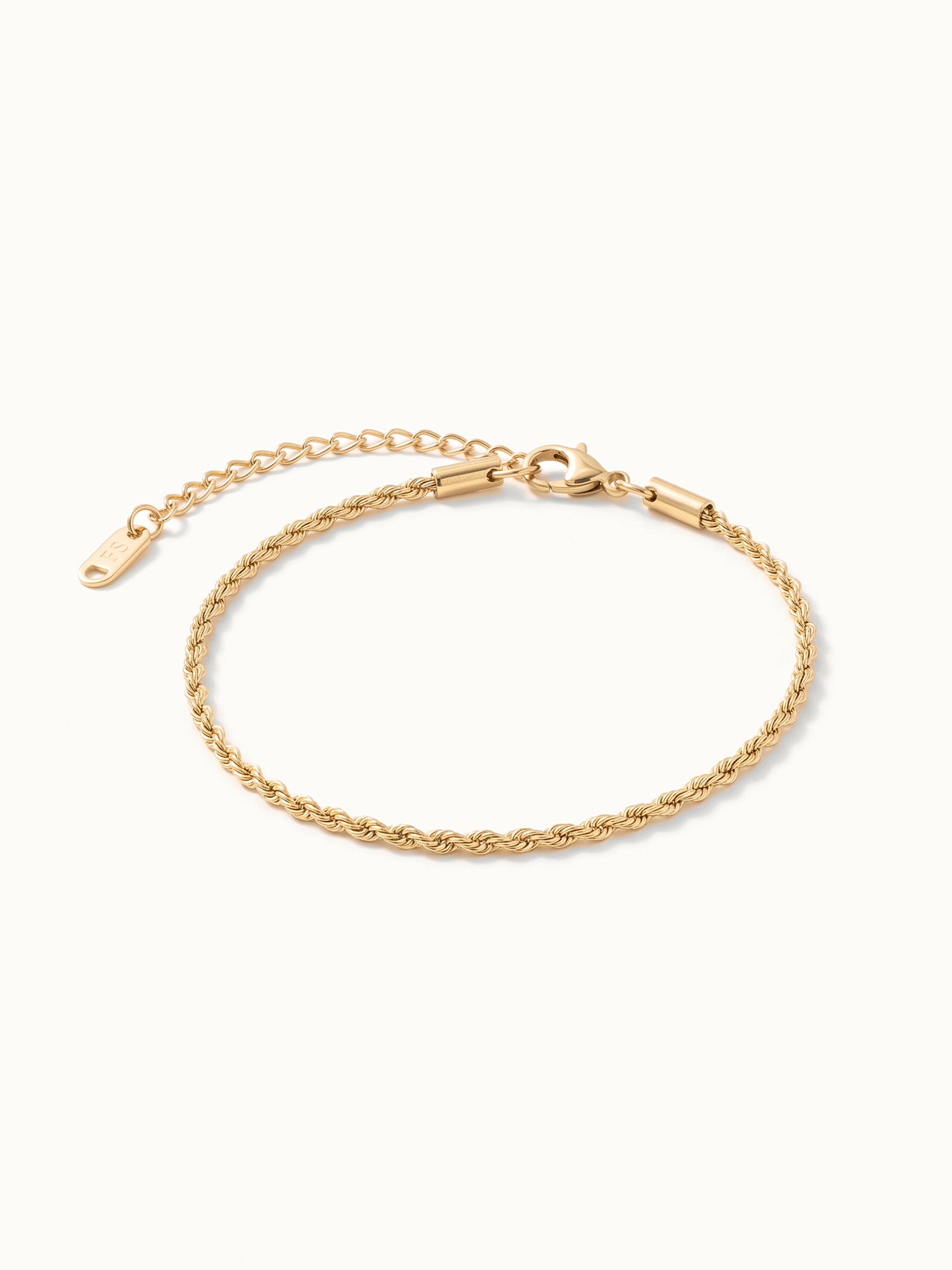 Morning Light Twist Bracelet – flat lay with clasp and extender, angled view, gold, on ivory background