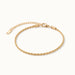 Morning Light Twist Bracelet – flat lay with clasp and extender, angled view, gold, on ivory background