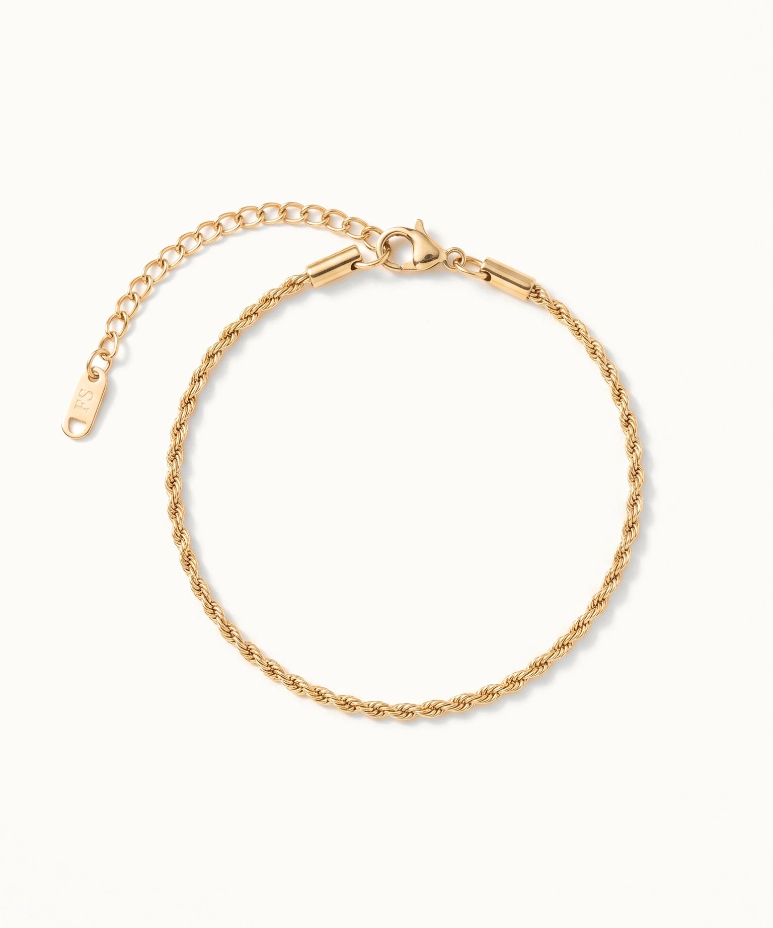 Morning Light Twist Bracelet – laid in a circle, seen from above, gold, on ivory background
