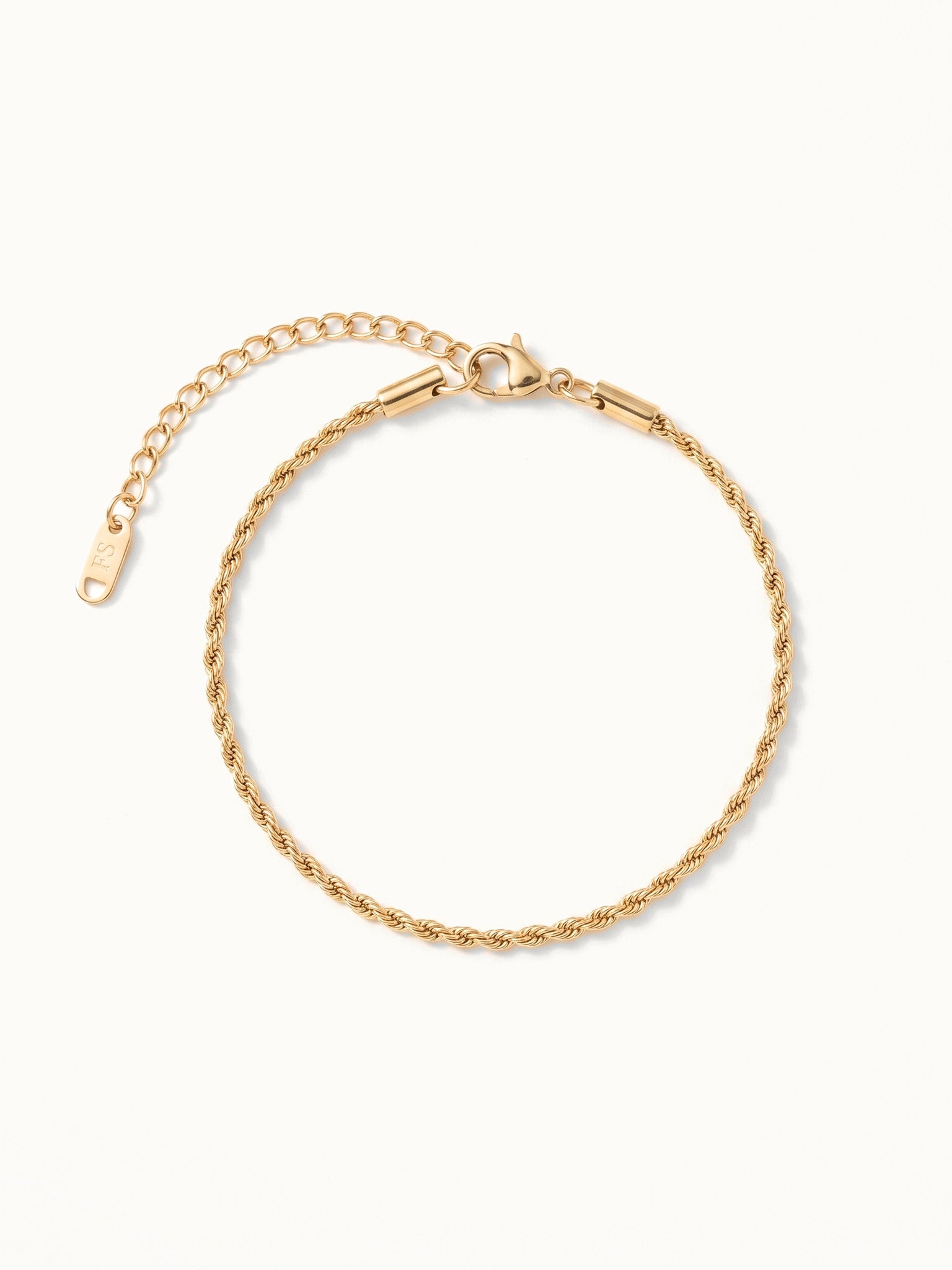 Morning Light Twist Bracelet – laid in a circle, seen from above, gold, on ivory background