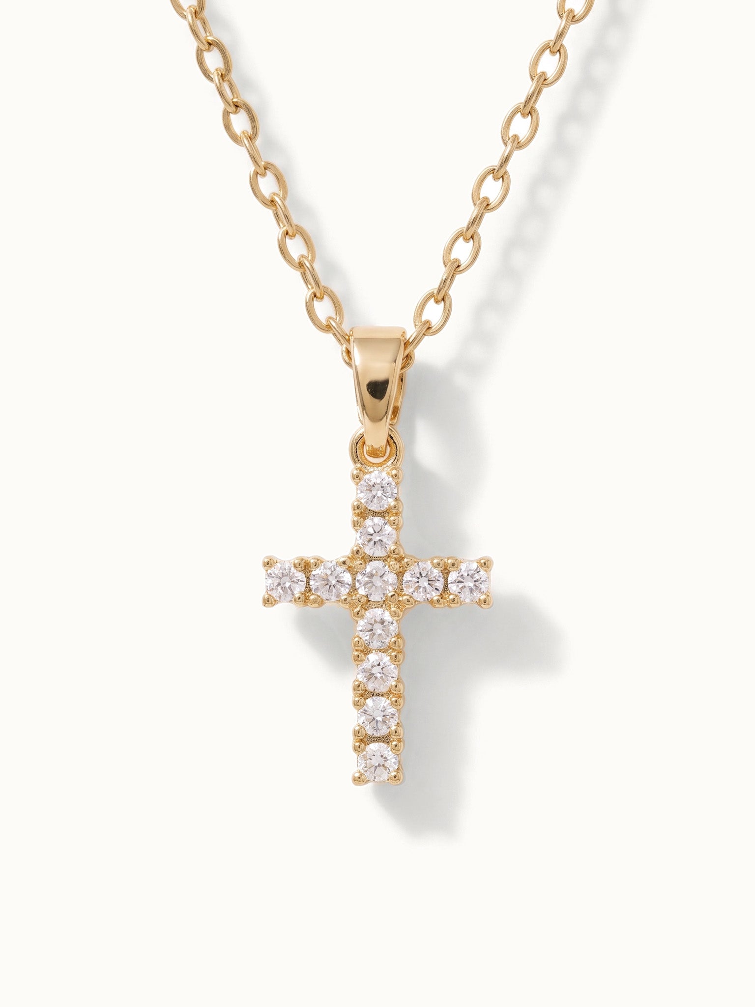 Radiant Cross Necklace in gold, close-up of the stone-set cross, alternative framing