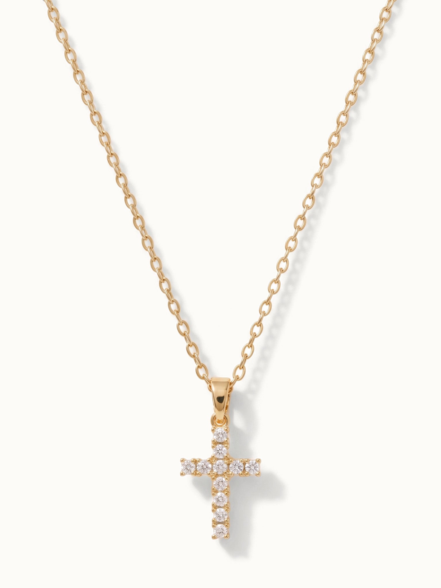 Radiant Cross Necklace in gold, hanging on a fine chain
