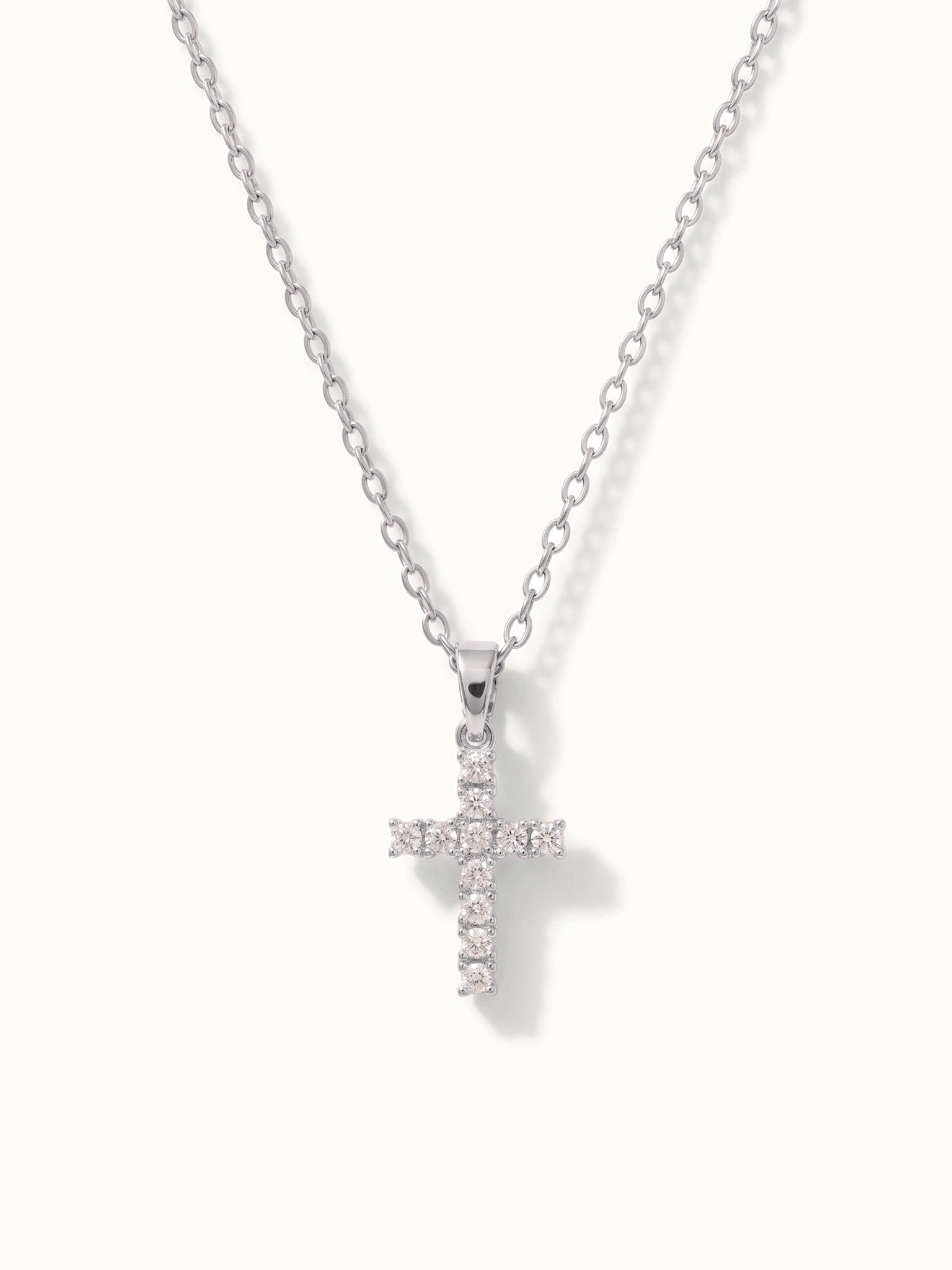 Radiant Cross Necklace in silver, hanging on a fine chain, alternative framing