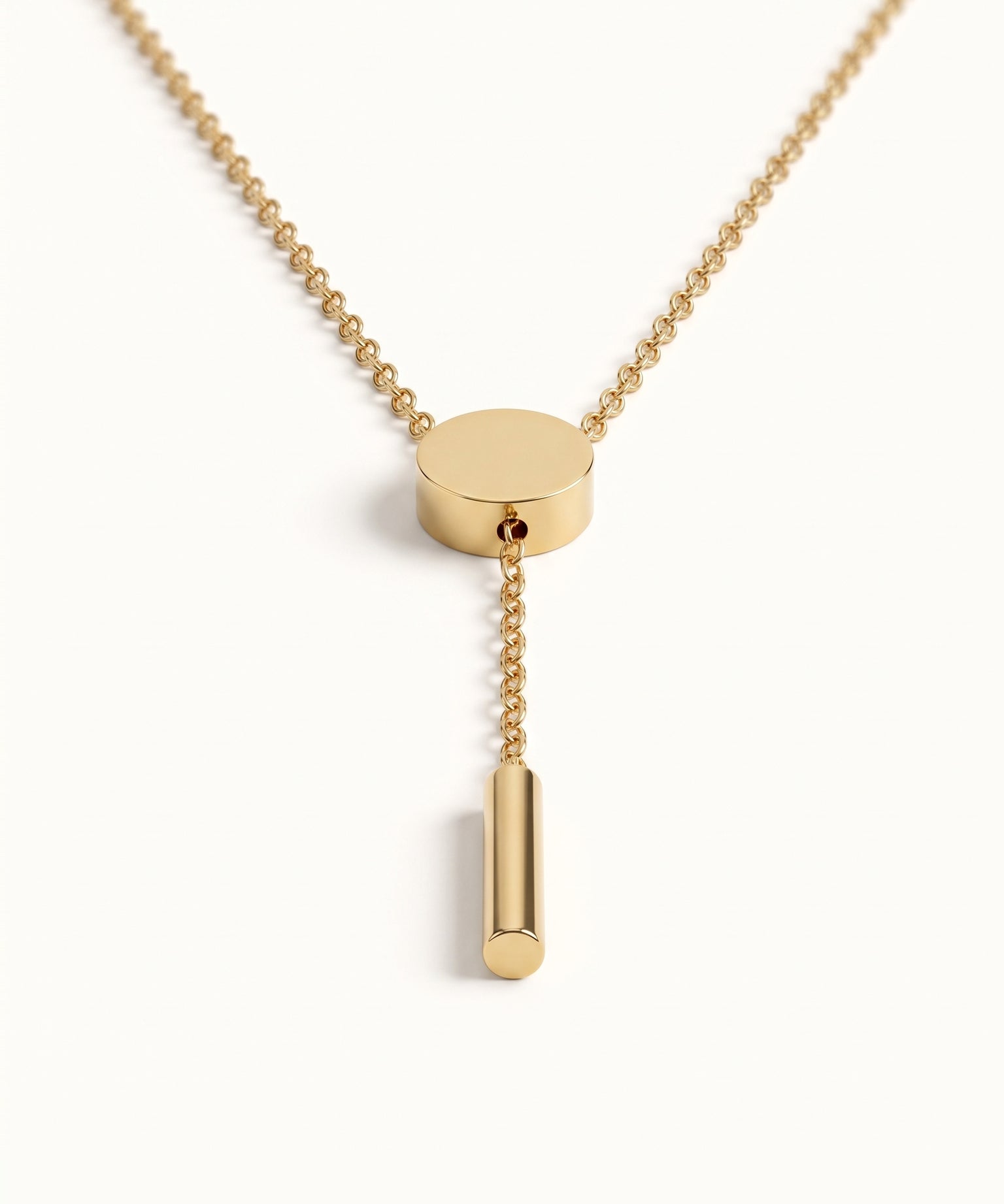 Rising Lariat Necklace – lariat hanging straight with disc slider and bar drop, gold, on ivory background
