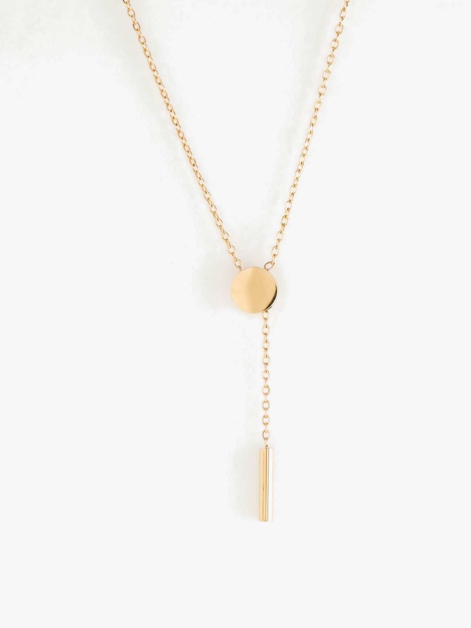 Rising Lariat Necklace – lariat hanging straight, disc and bar drop, gold, on white background
