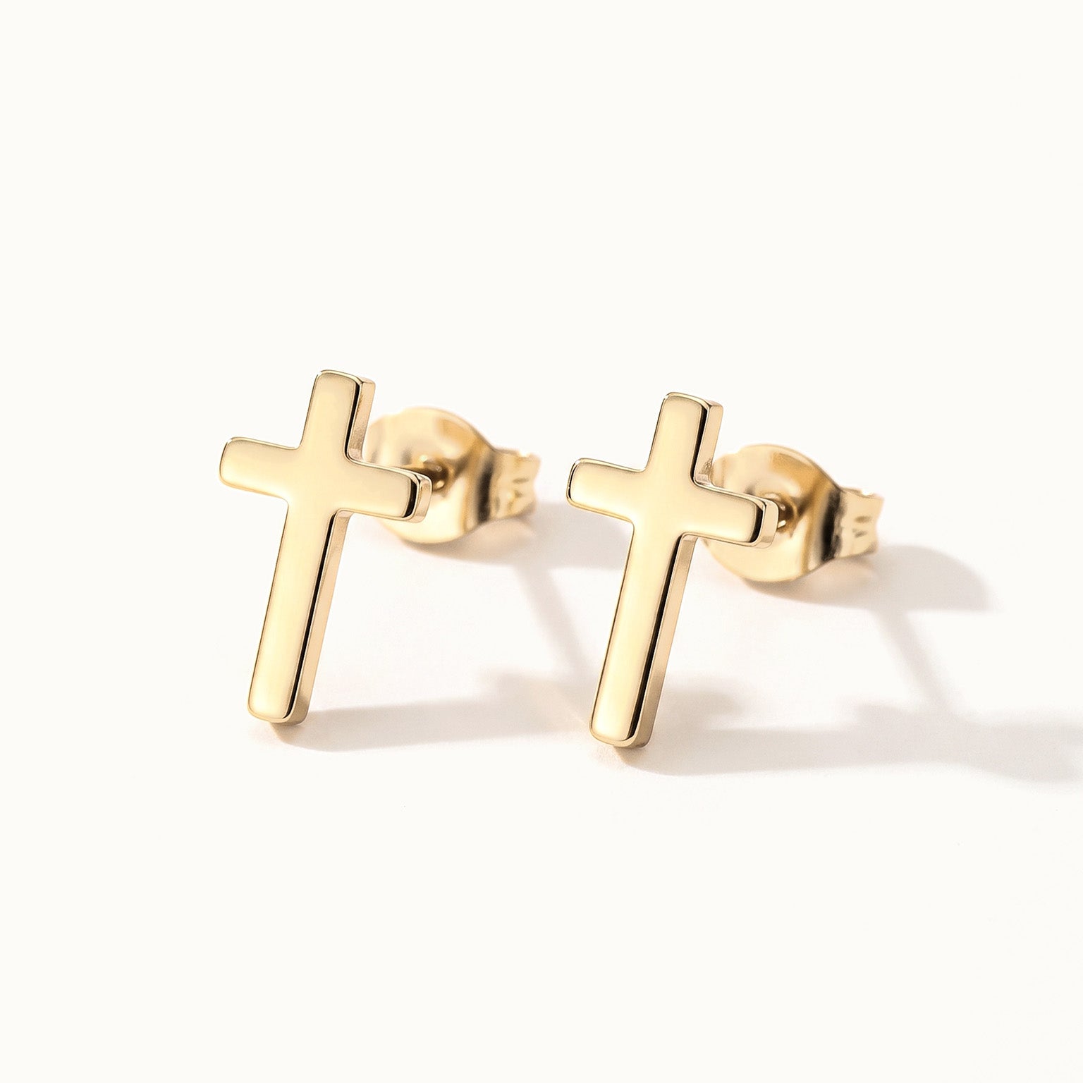 Rooted Cross Studs – pair of cross studs, gold, on ivory background