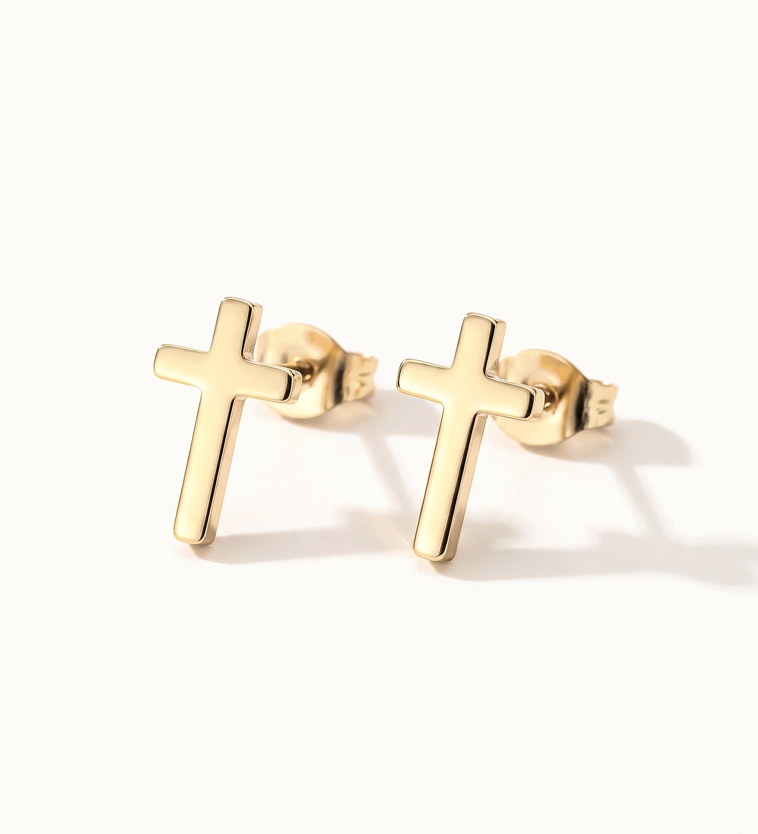 Rooted Cross Studs – pair of cross studs, gold, on ivory background