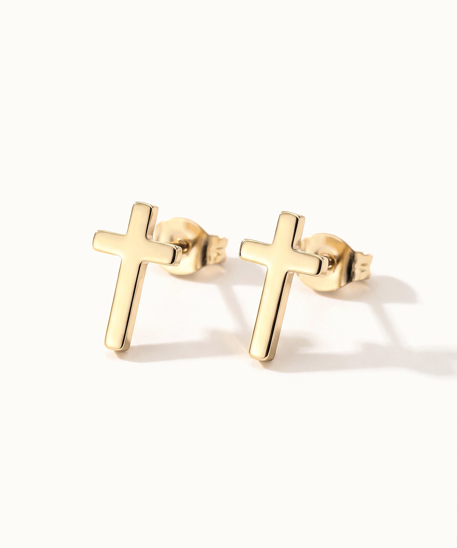 Rooted Cross Studs – pair of cross studs, gold, on ivory background