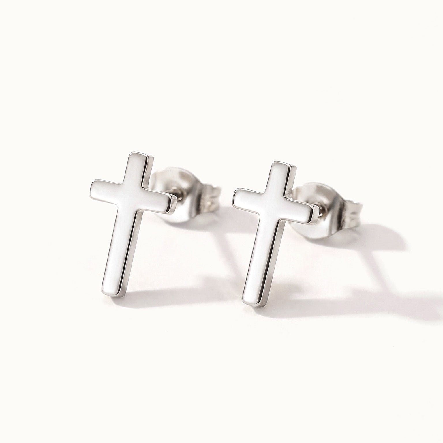 Rooted Cross Studs – pair of cross studs, silver, on ivory background
