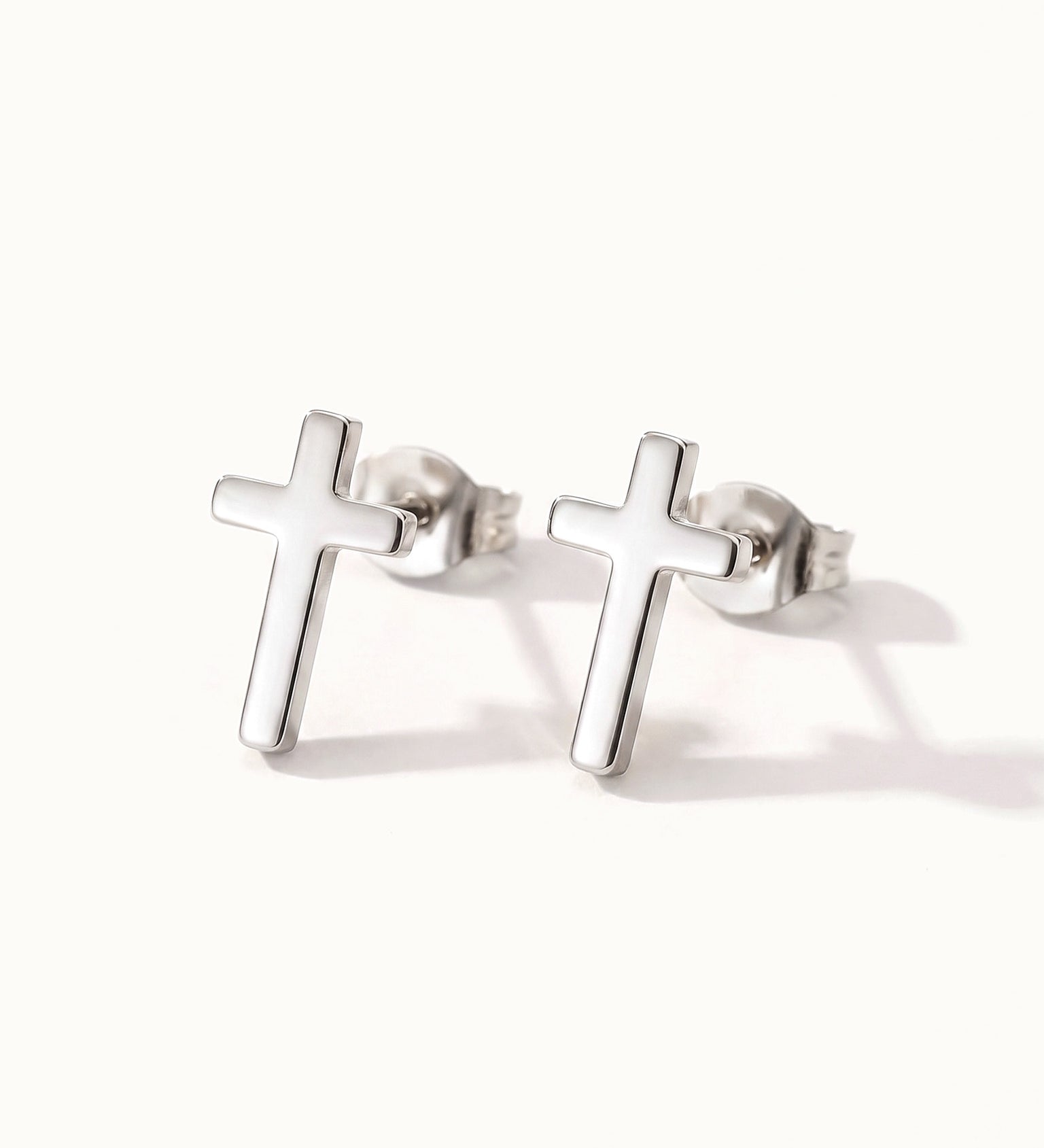 Rooted Cross Studs – pair of cross studs, silver, on ivory background