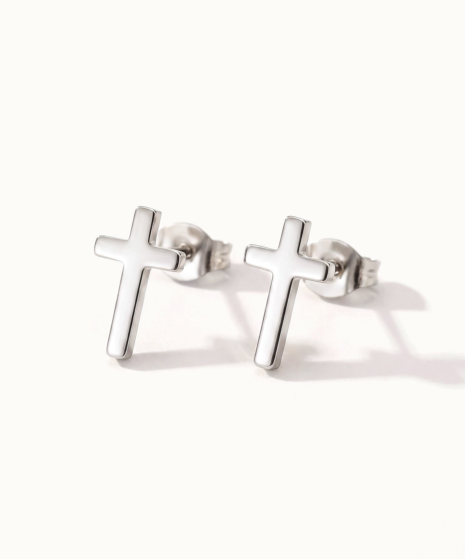 Rooted Cross Studs – pair of cross studs, silver, on ivory background