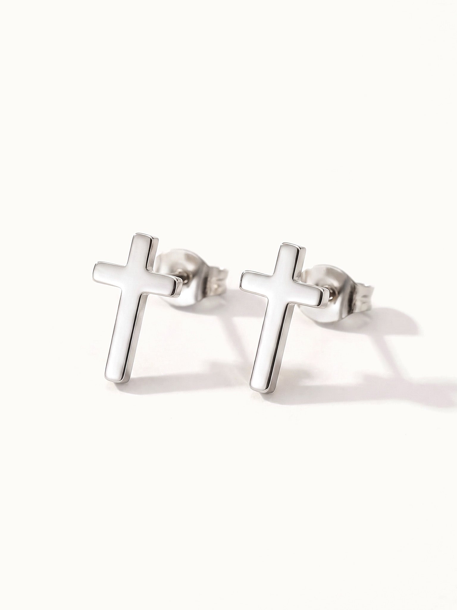 Rooted Cross Studs – pair of cross studs, silver, on ivory background