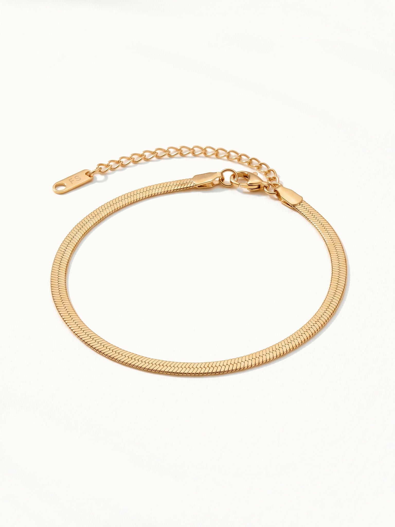 Still Waters Herringbone Bracelet – flat lay with clasp and extender, angled view, gold, on ivory background