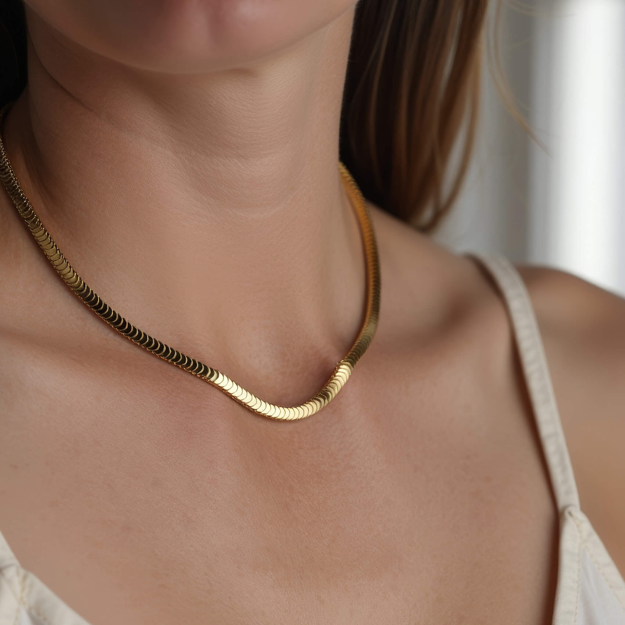 Still Waters Herringbone Necklace in gold worn on a woman's neck