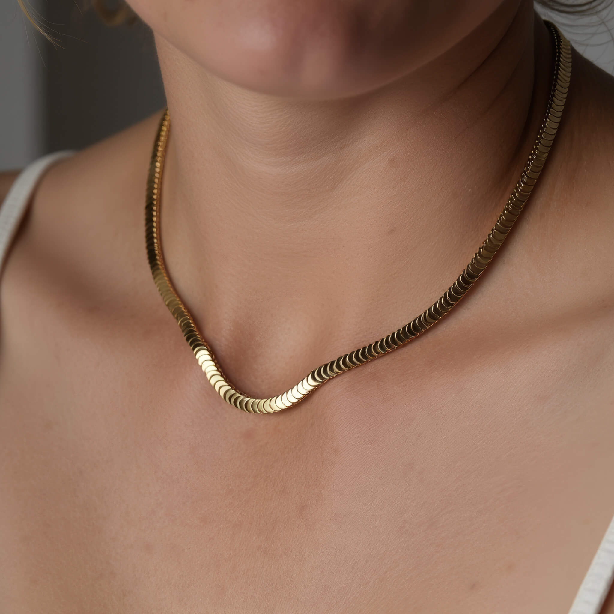 Still Waters Herringbone Necklace – worn close at the collarbone, gold, white strap top