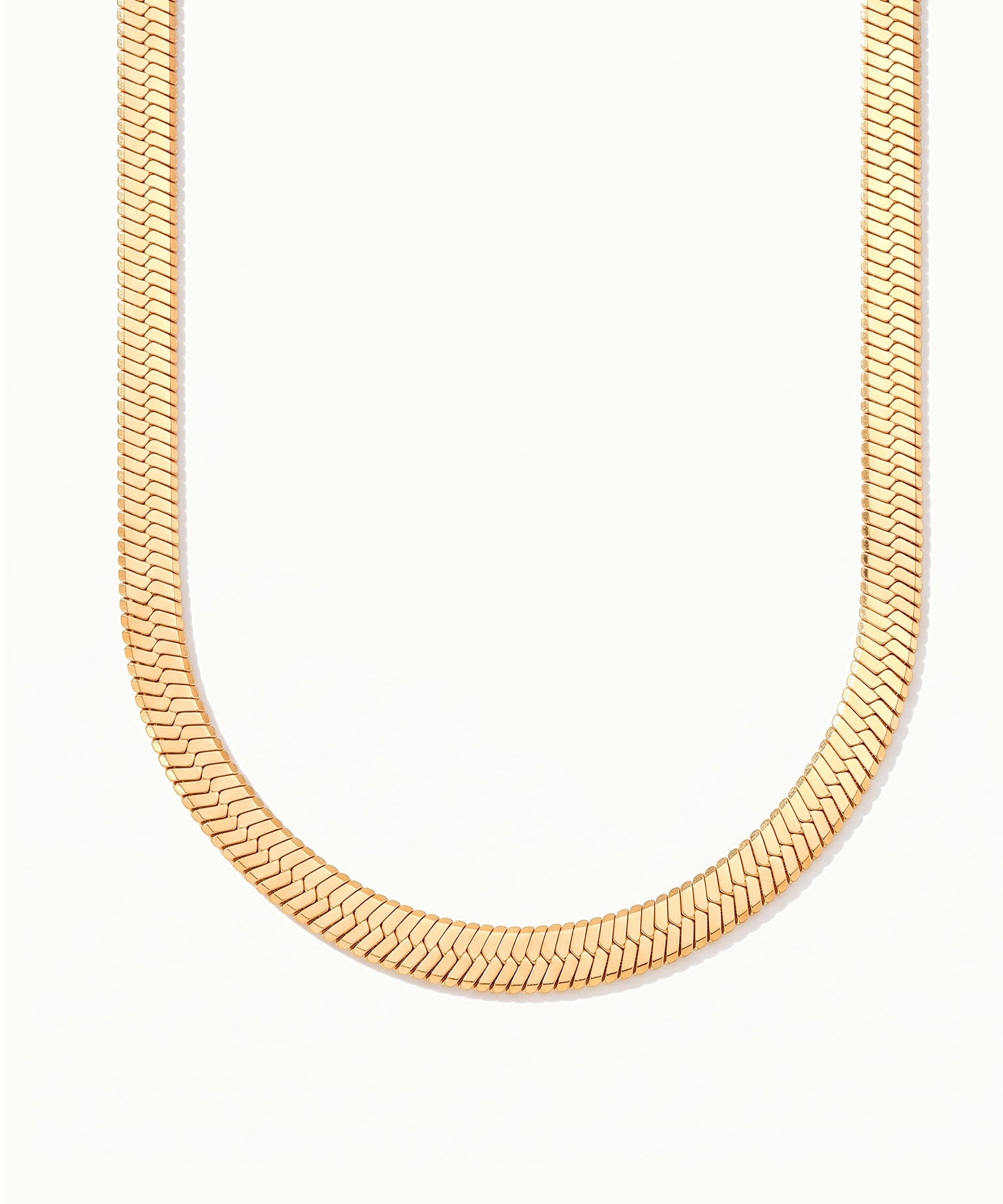 Sunday Best Herringbone Necklace – wide flat herringbone chain hanging in a drop, gold, on ivory background