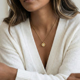 True North Necklace in gold worn with a white knit cardigan