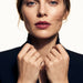 Whisper Band Ring – worn with both hands holding the blazer collar, gold, dark blazer, ivory studio background