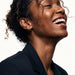 Whisper Hoops – worn in the ear, laughing with head tilted back, gold, curly hair up