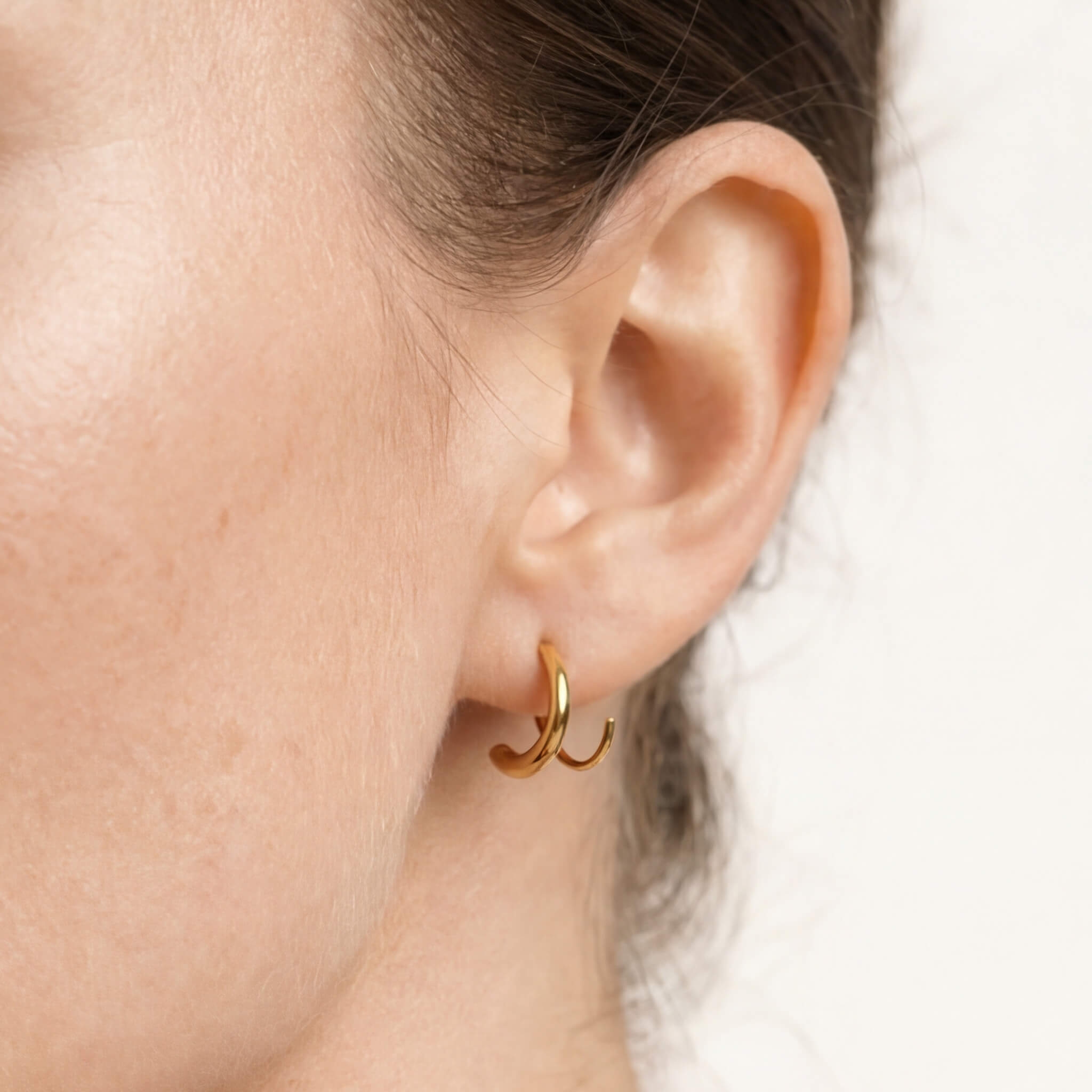 Whisper Hoops – worn in the ear, close-up of the curve, gold, hair tied back