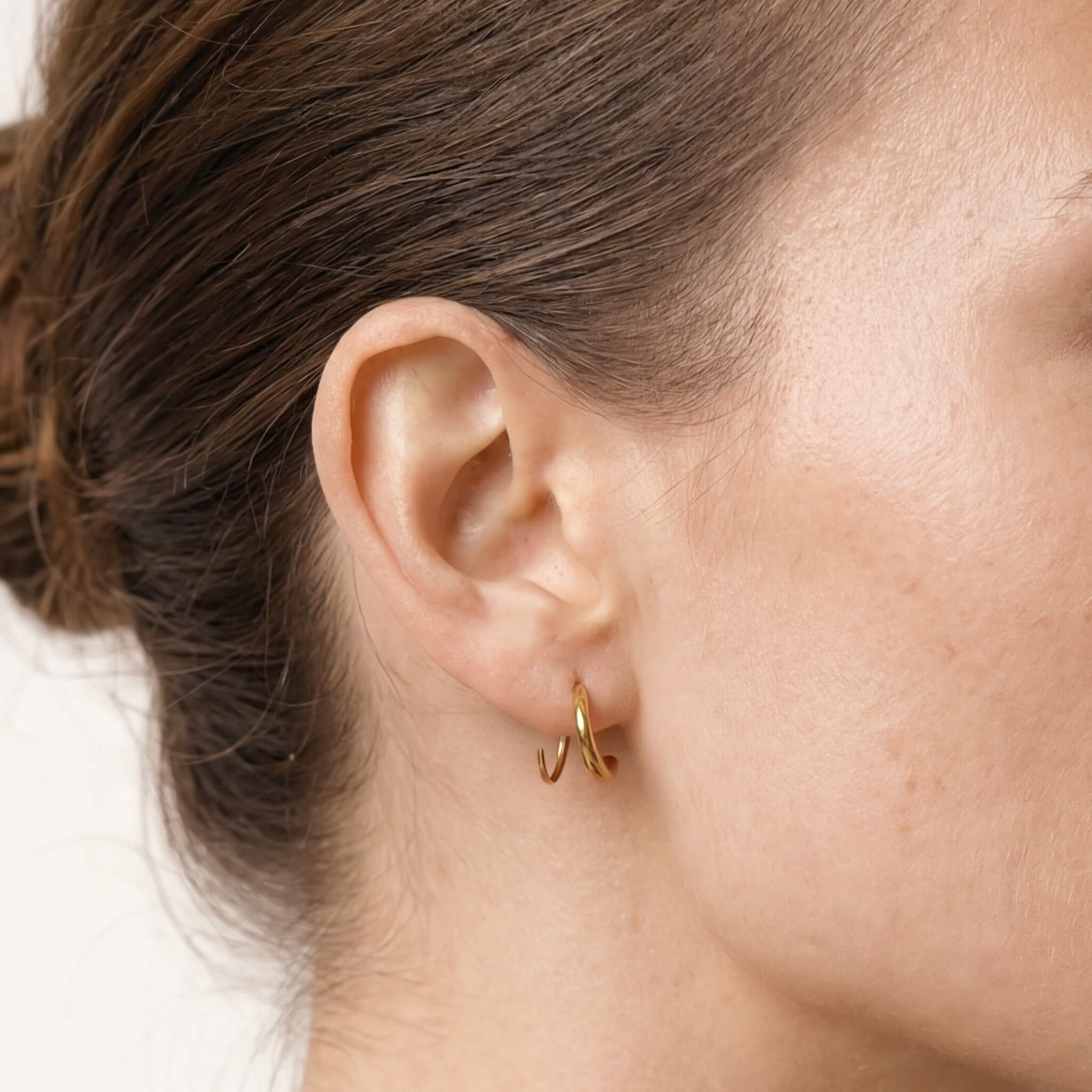 Whisper Hoops – worn in the ear, side profile, gold, hair in a low bun