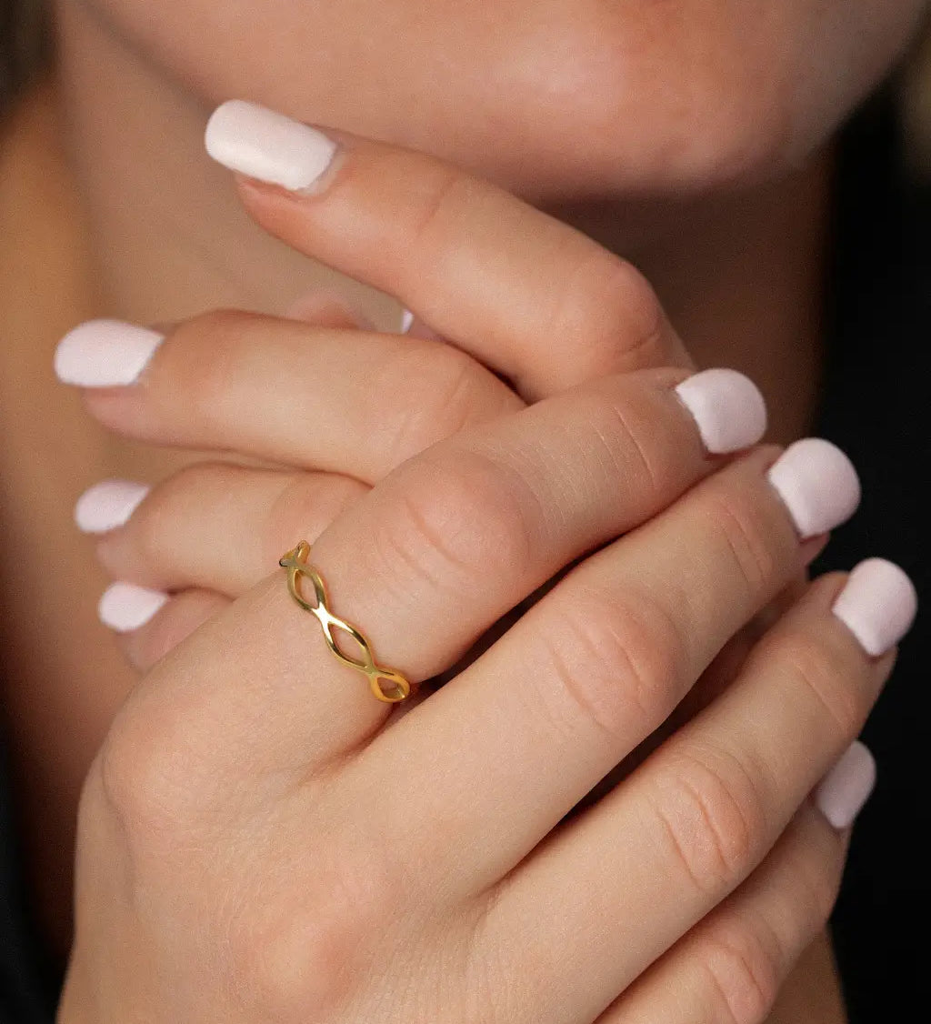 Woven Eternity Ring in gold worn on a woman's hand clasped beneath her chin