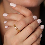 Woven Eternity Ring in gold worn on a woman's hand clasped beneath her chin